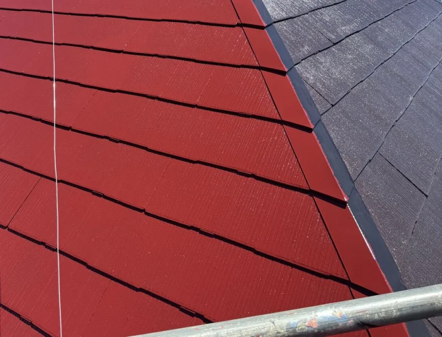 八王子市内の戸建て 中塗り途中の屋根 隅棟の棟板金の片側だけ赤く塗られた状態